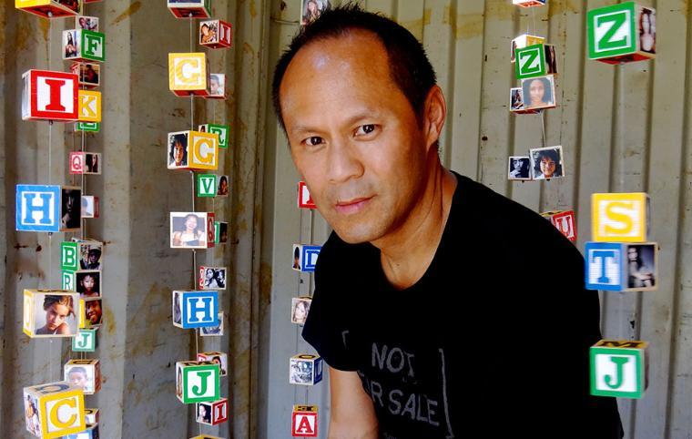 A person posing in front of a colorful backdrop. image link to story