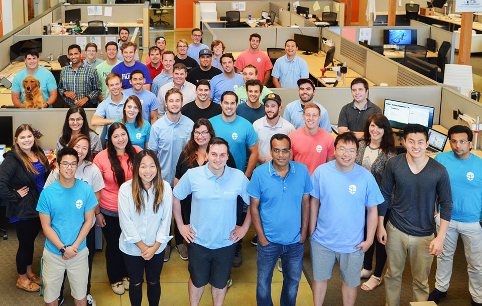 A group of people posing inside an office with Onerent branding. image link to story