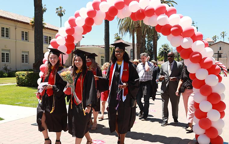 Students walking toward the stage for graduation 2021