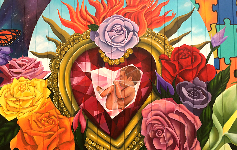 A mural painting with a baby inside of a heart