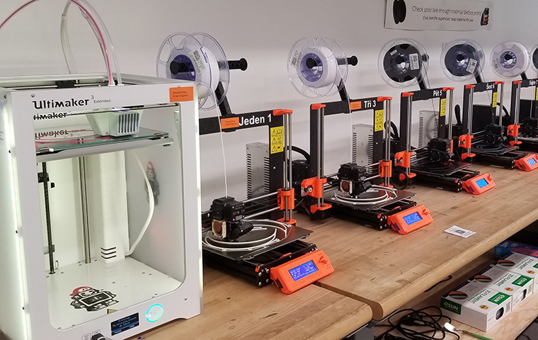 A row of 3D printers in the Maker Lab