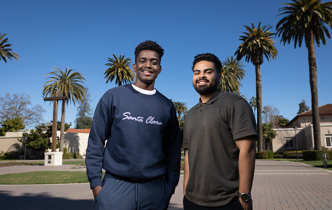 Niyibitanga Inosa ’23 and Antonio Magallanes ’23 stand in front of palm trees on Santa Clara's campus