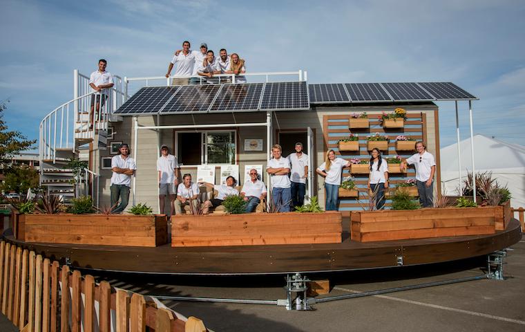 A team posing in front of a modern, solar-paneled building. image link to story