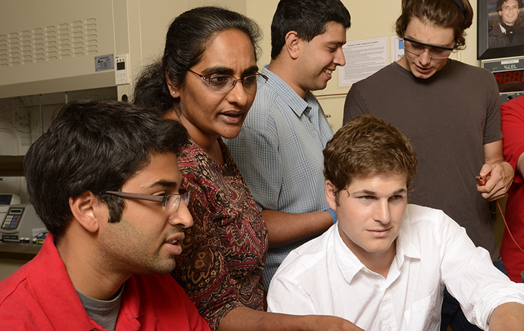 Shoba Krishnan looks over the shoulder of two students