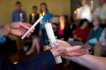 A candle is lit with another during mass 