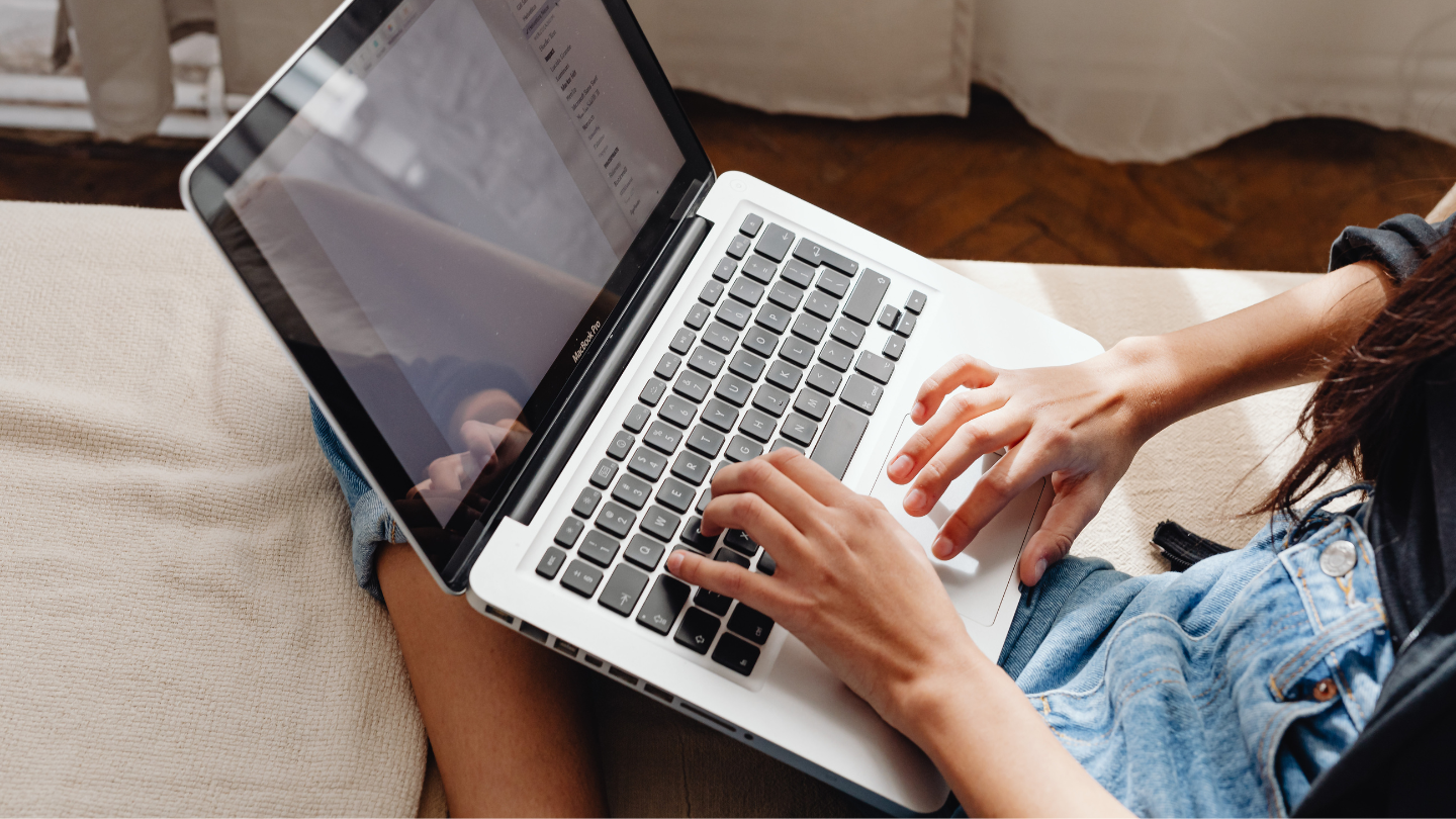 An individual's hands typing on a computer. 