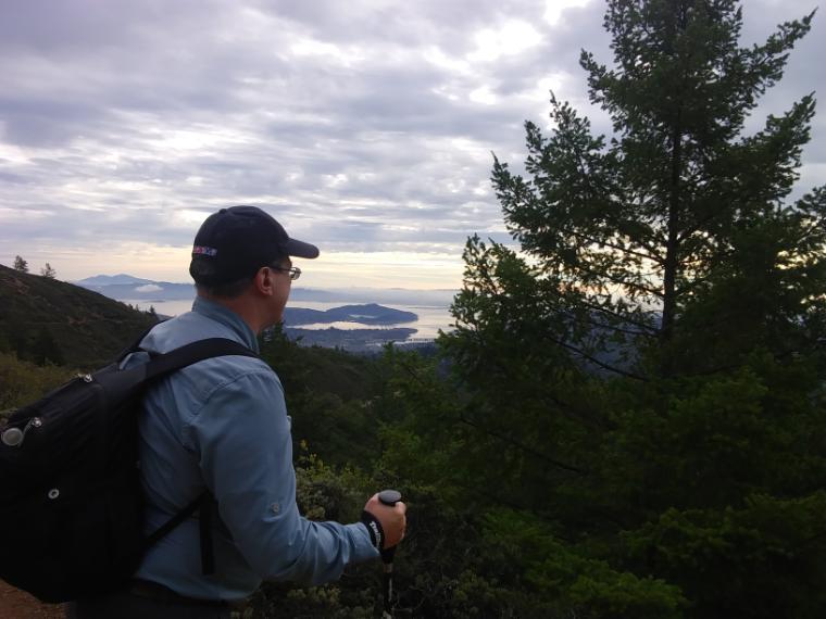 Person hiking up Mt. Tamalpais with a scenic view of trees and mountains.