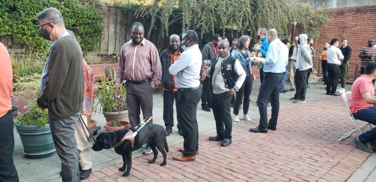 People lining up outdoors at a BBQ event.