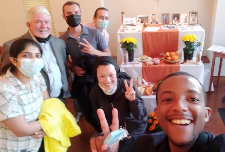 Group of people smiling in front of Day of the Dead decorations.