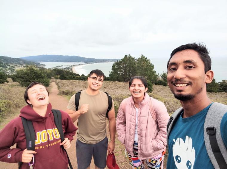 Four students hiking Mt. Tamalpais, smiling at the camera with a scenic background.