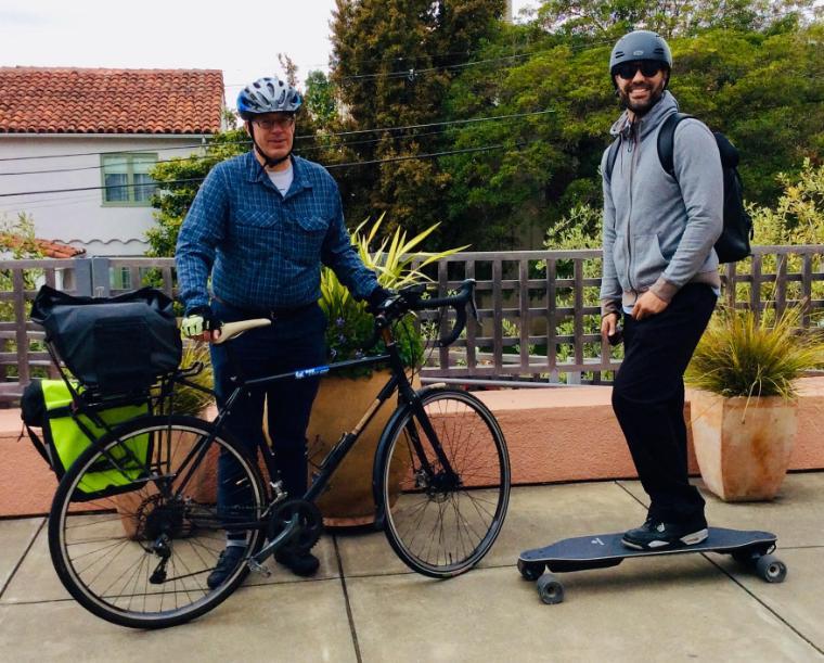 Two people with bike and electric skateboard, captioned 'JFR, ML eco-friendly transport'. Photo by Mary Beth Lamb.
