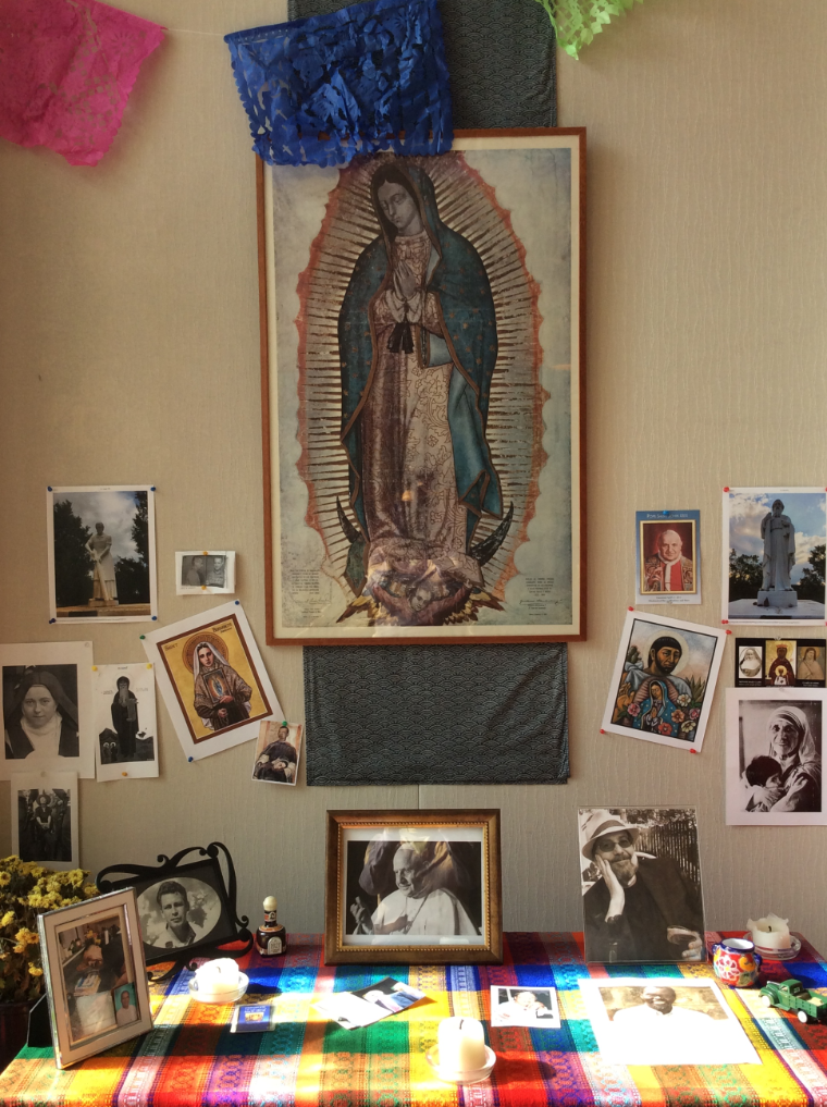 altar with pictures of loved ones and saints
