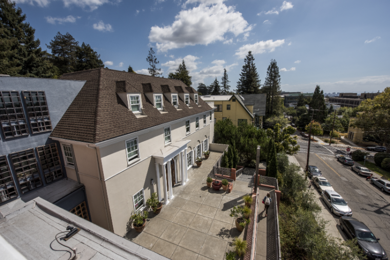 Alt text: Exterior view of JST front entrance with surrounding trees and street.