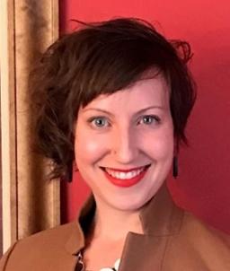 A woman smiling in front of a red background.