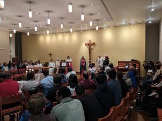 A person speaking to an audience in a large, well-lit room.