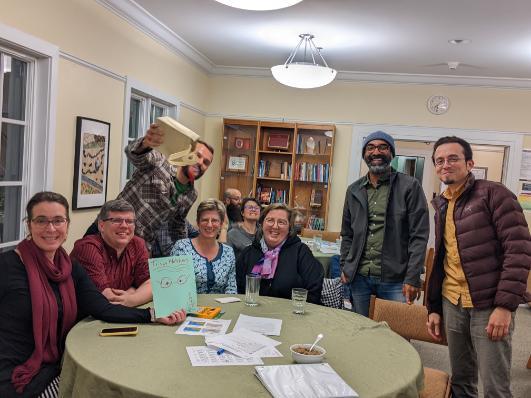 Group of people celebrating trivia win in a library.