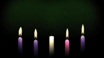 Five lit candles representing Advent, with a dark background.