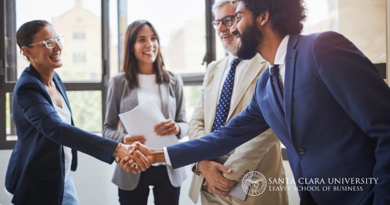 Business professionals smiling and shaking hands