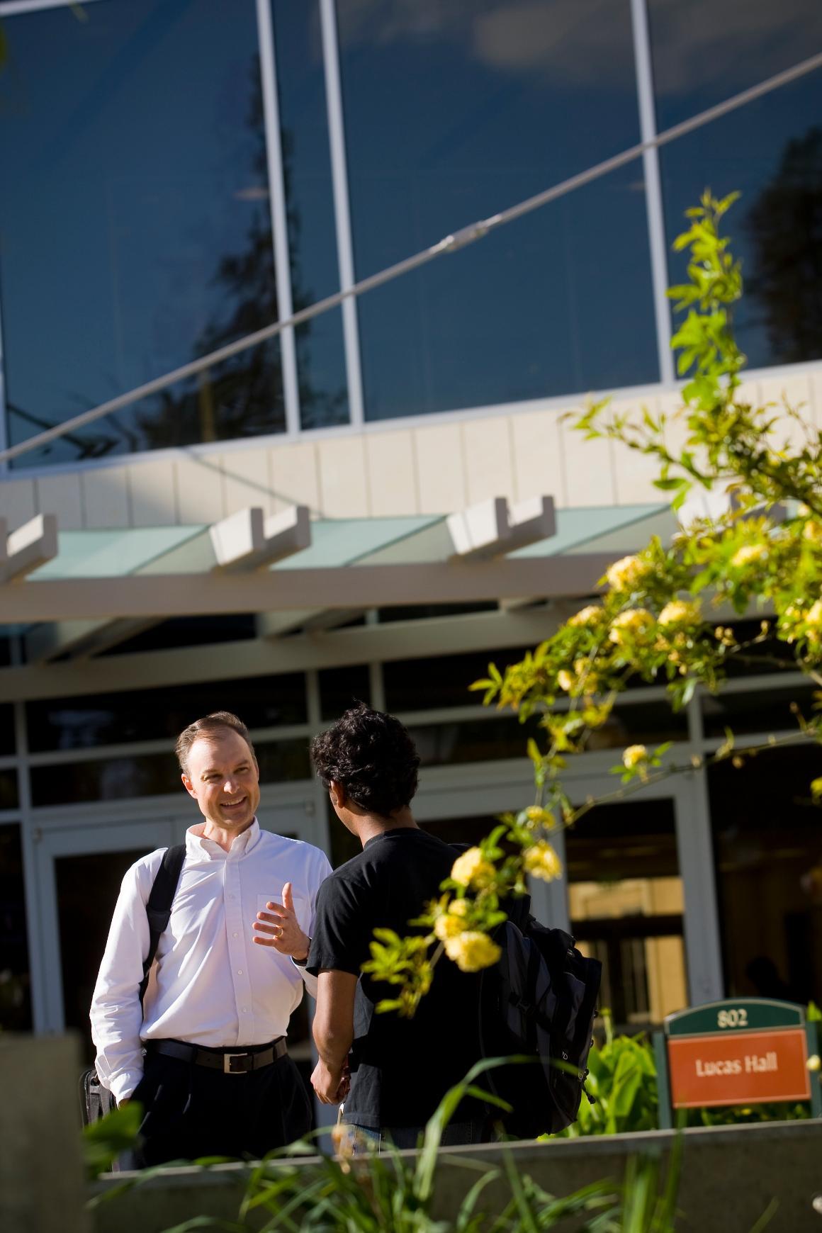 Leavey School of Business faculty engaging in lively discussions with a student