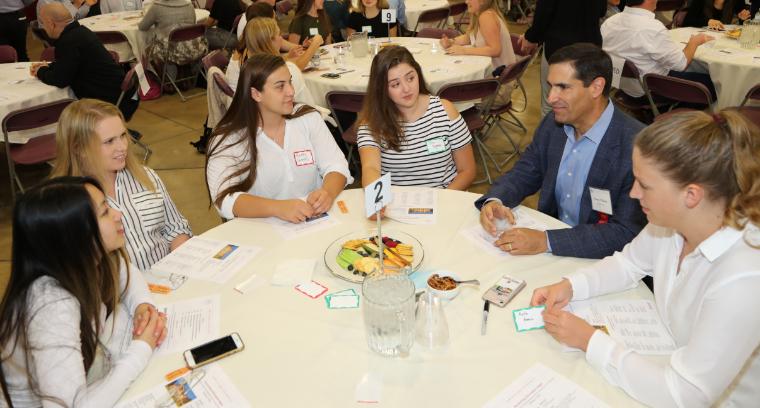 Alumni Greg Vlahos sitting with students at Accounting Information Night image link to story