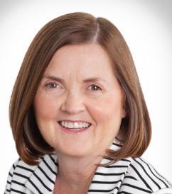 Alt text: Woman smiling, wearing a striped blazer and red shirt.