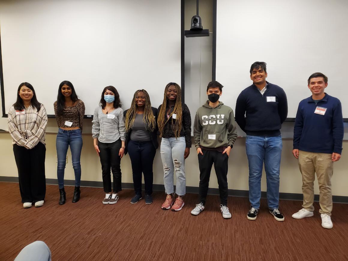 A group of undergraduates standing in a line indoors.
