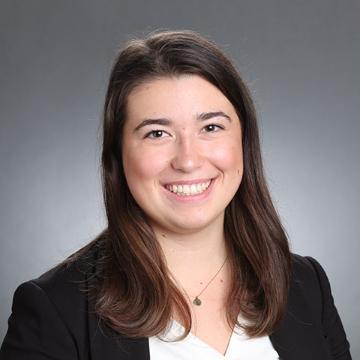 Woman in black blazer and white top smiling