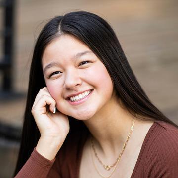Girl smiling resting her head on her hand