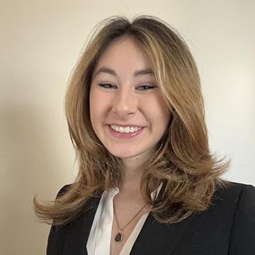 Woman in black blazer and white top smiling