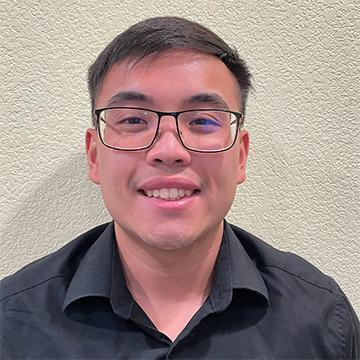 Man with glasses and black shirt smiling