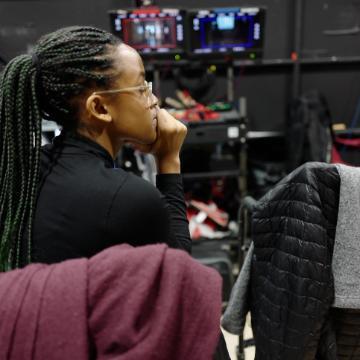 A person sitting and observing something in front of them.
