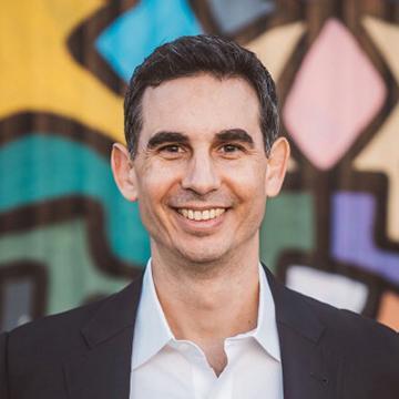 Man smiling in white shirt and black jacket