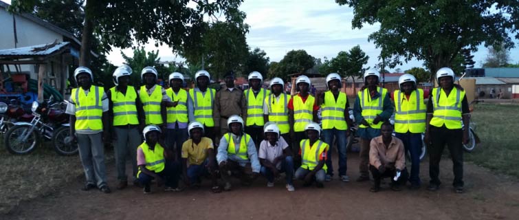 Group of people in high-visibility vests posing outside.