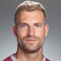 A person wearing a maroon jersey posing for a headshot photo.