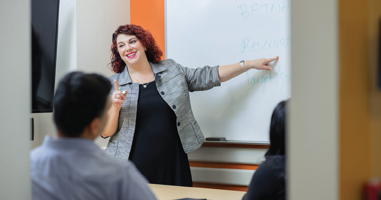 Professor Jo-Ellen Pozner teaching students on a whiteboard