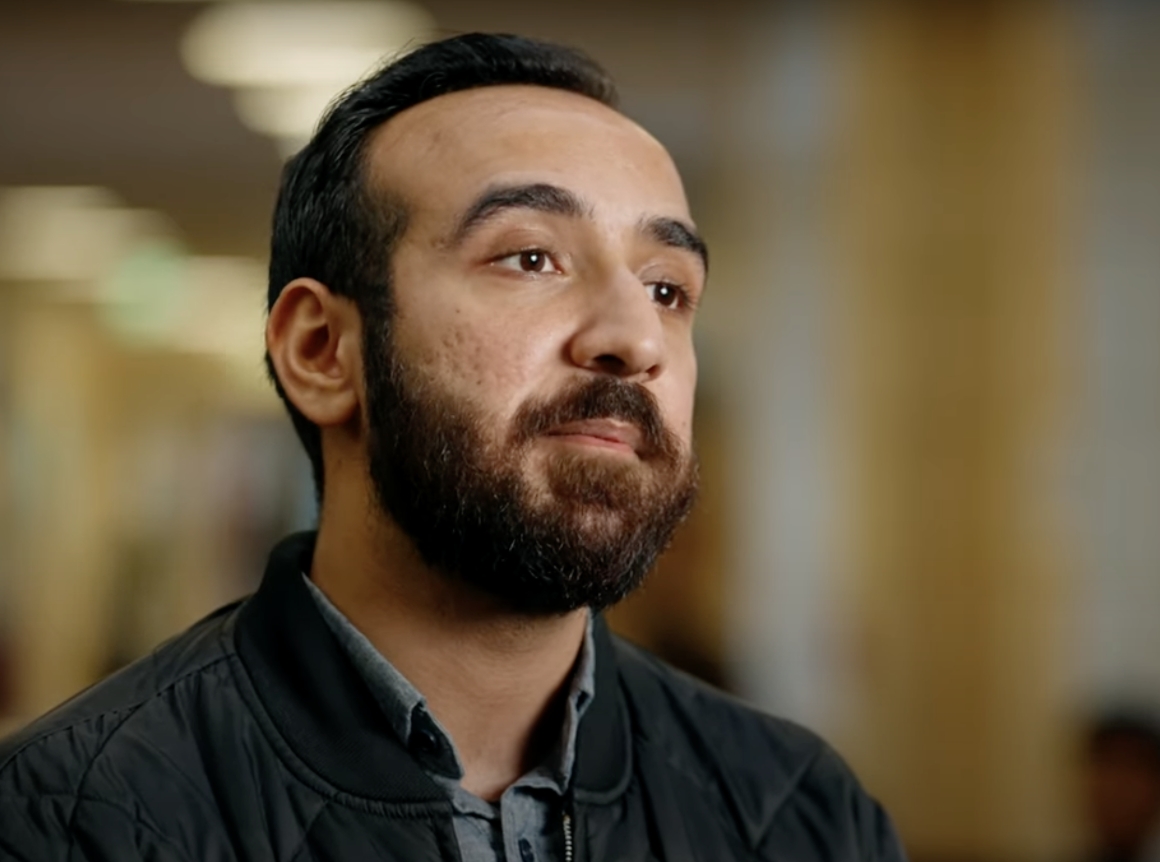 Red and white flowers with a stadium in the background amidst palm trees.