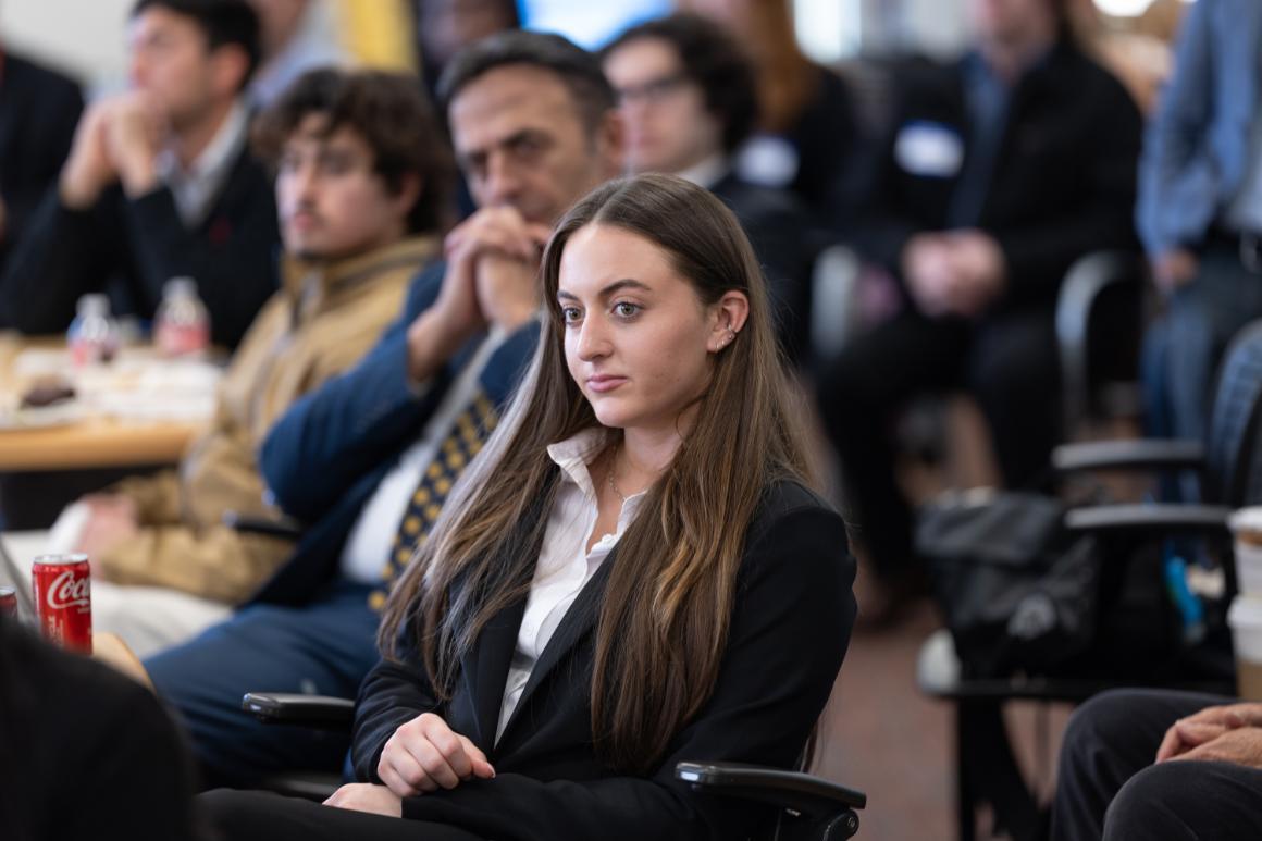 Business student in crowd listening intently to a presentation