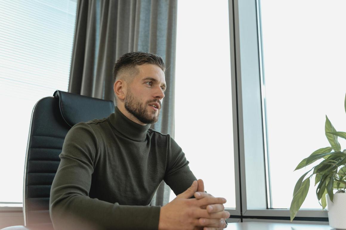 Business professional in turtleneck with hands clasped
