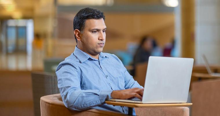 Leavey MBA candidate on laptop in Lucas Hall