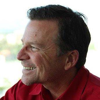 A man smiling in a profile view.