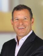 A person in a suit smiling at the camera.