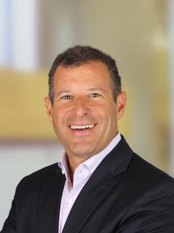 A person in a suit smiling at the camera.