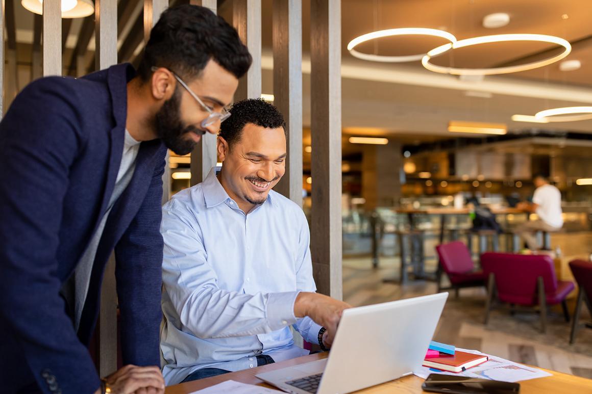 Leavey graduate students discussing concepts displayed on a laptop
