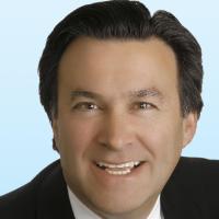 A man in a suit and tie smiling.
