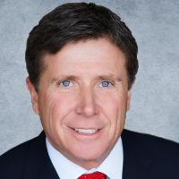 A man wearing a suit and red tie.