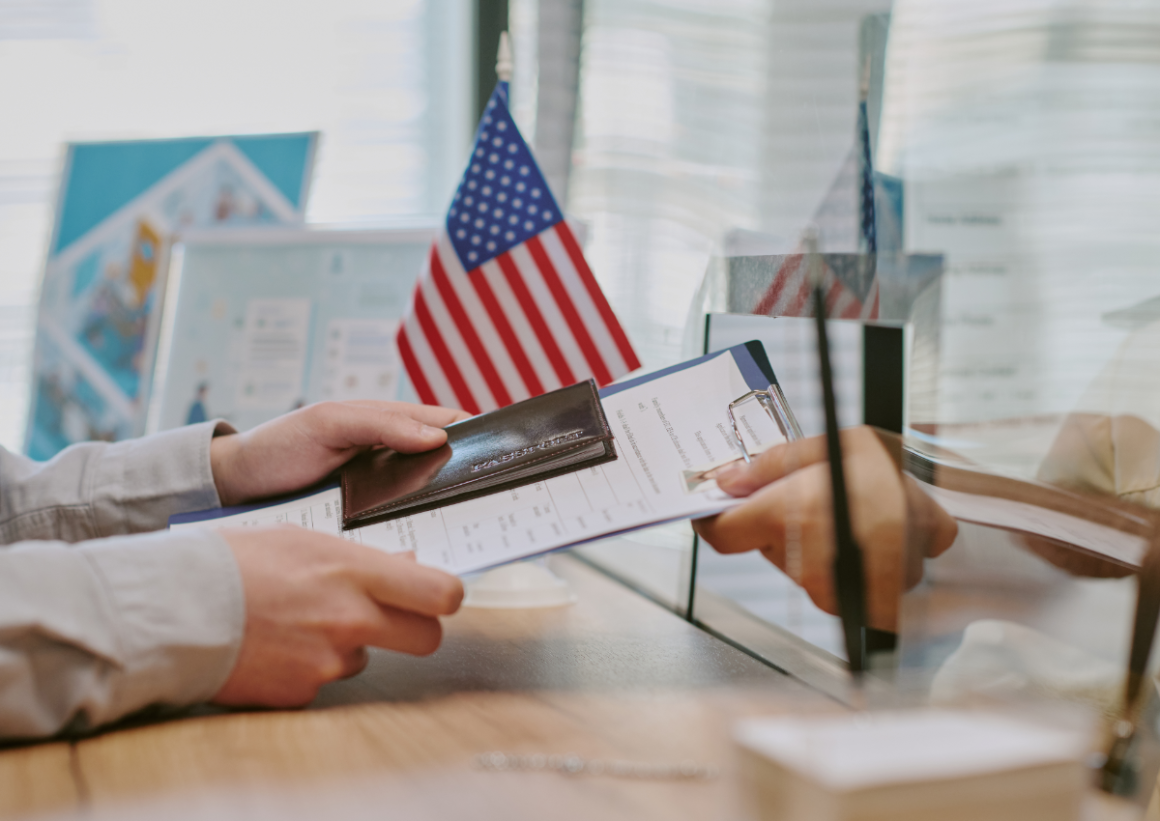 Student handing passport and paperwork to US visa official
