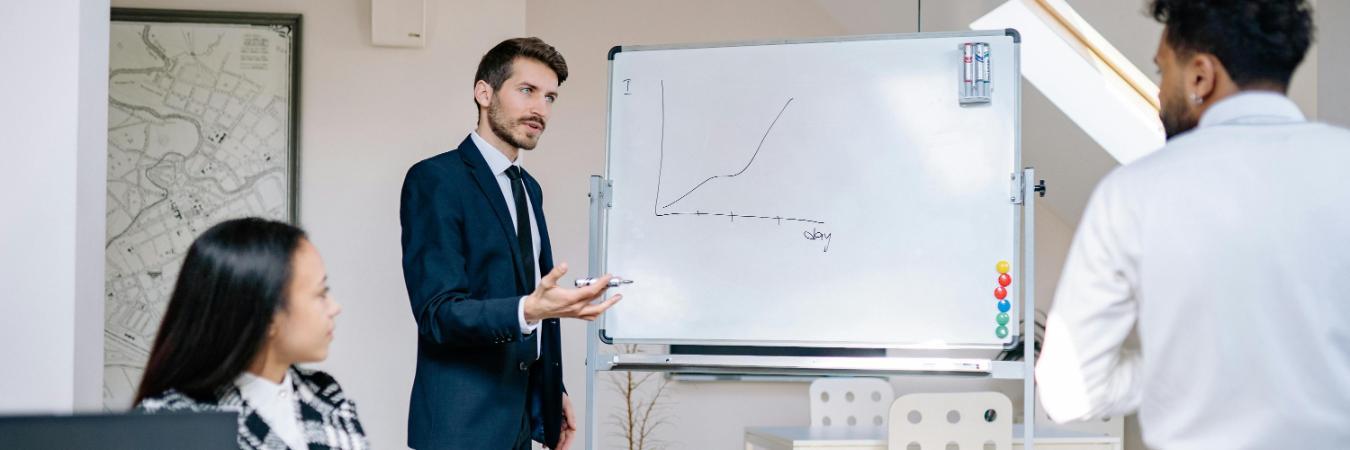 Business professional in suite explaining graph to colleagues