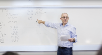 A person teaching concepts written on a whiteboard.