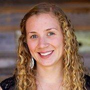 A woman smiling in a professional headshot with a blurred background.