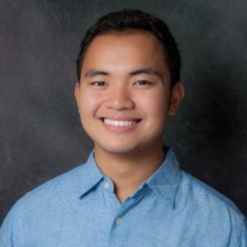 A man smiling in a professional headshot.